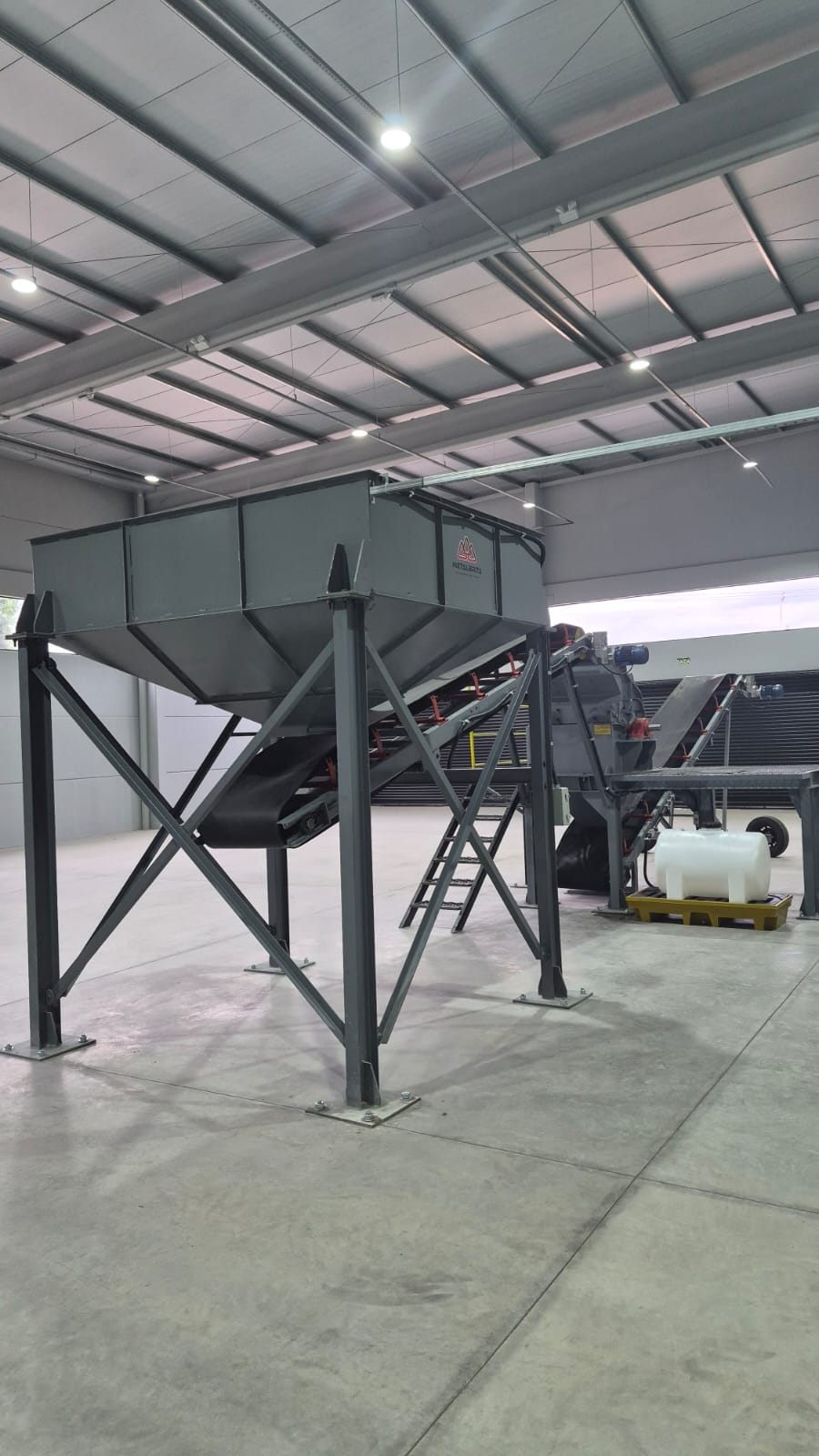 Silo metálico de armazenagem e correia de alimentação da linha de produção.